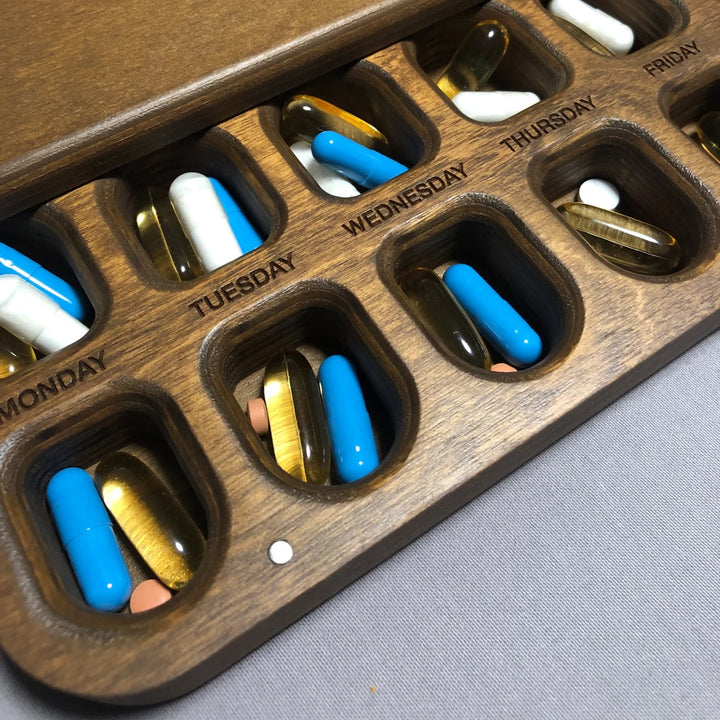 Wooden pill organizer for weekly medication schedule
